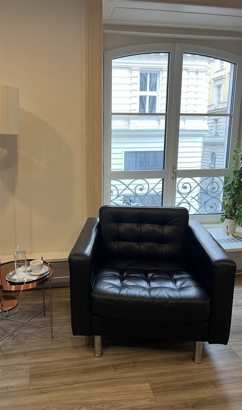 Wartebereich mit Ledersessel und Espresso am Fenster